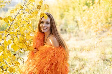 Sonbahar ormanında gece makyajlı ve parlak elbiseli bir kız.