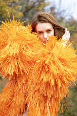 Sonbahar ormanında gece makyajlı ve parlak elbiseli bir kız.