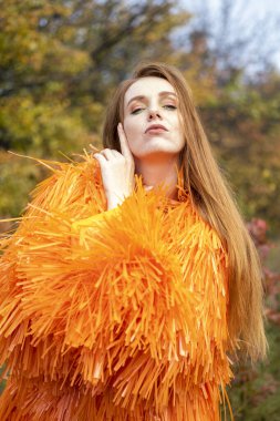 Sonbahar ormanında gece makyajlı ve parlak elbiseli bir kız.