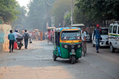 Delhi, Hindistan - 20 Kasım 2015: Renkli Tuk-Tuk araç ve hava kirliliğinin görünür smog ile Delhi kalabalık bir trafikte yayaların