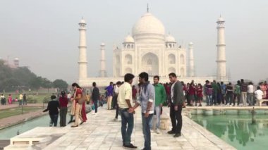 Agra, Hindistan - 29 Kasım 2015: Turistlerle ünlü Taj Mahal - Mughal imparatoru Şah Cihan tarafından eşi Mumtaz Mahal 'in anısına yapılan devasa beyaz mermer mozolesi