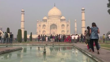 Agra, Hindistan - 29 Kasım 2015: Turistlerle ünlü Taj Mahal - Mughal imparatoru Şah Cihan tarafından eşi Mumtaz Mahal 'in anısına yapılan devasa beyaz mermer mozolesi