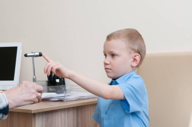 Küçük çocuk kliniğinde muayene sırasında refleks çekici ile