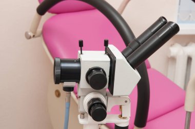The colposcope on the background of gynecological chair clipart
