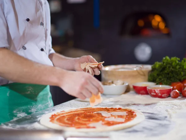 Koch Legt Wurst Oder Schinken Über Pizzateig Auf Küchentisch — Stockfoto