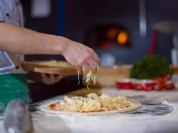 Şef Mutfak Masasında Taze Pizza Hamurunun Üzerine Peynir Serpiyor — Stok fotoğraf