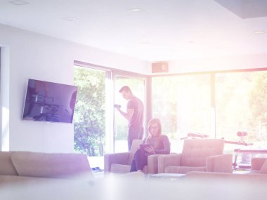 Genç çift rahatlatıcı, tablet bilgisayarlar adam egzersiz için hazırlanıyor süre kullanan lüks ev kadın