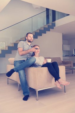 Mutlu romantik çift, lüks evlerinde televizyon izliyorlar.