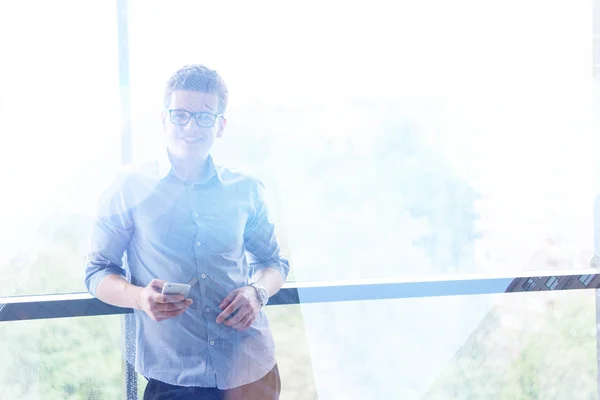 Geschäftsmann Mit Telefon Neben Fenster Eines Modernen Büros — Stockfoto