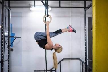 çapraz jimnastik jimnastik halkaları üzerinde çalışan genç atletik kadın