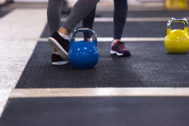 Çapraz fitness stüdyosunda kettlebell egzersizleri yapan bir grup sağlıklı genç sporcu.