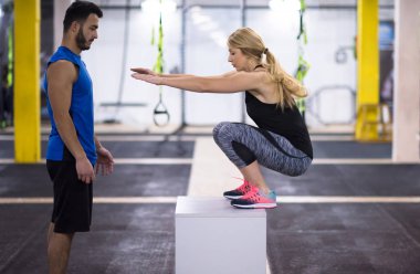 Kişisel antrenörle antrenman yapan genç atletik kadın spor salonunda forma giydi.