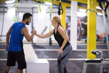 Kişisel antrenörle antrenman yapan genç atletik kadın spor salonunda forma giydi.