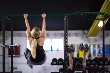 sporcu kadın fitness spor çapraz yatay çubuk üzerinde baş aşağı asılı abs egzersizleri yapıyor
