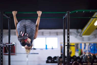 sporcu kadın fitness spor çapraz yatay çubuk üzerinde baş aşağı asılı abs egzersizleri yapıyor