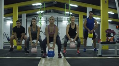 Güçlü kas atletleri, su tabancalarıyla idman yapıyor..