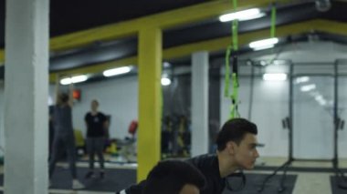 Güçlü kas atletleri, su tabancalarıyla idman yapıyor..