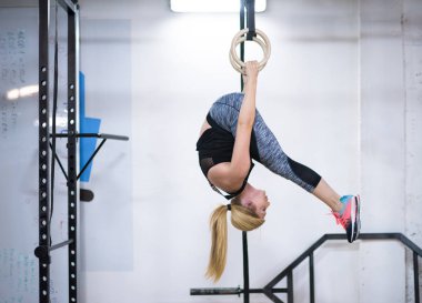 çapraz jimnastik jimnastik halkaları üzerinde çalışan genç atletik kadın