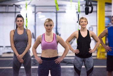 Çapraz fitness stüdyosunda kettlebell egzersizleri yapan bir grup sağlıklı genç sporcu.
