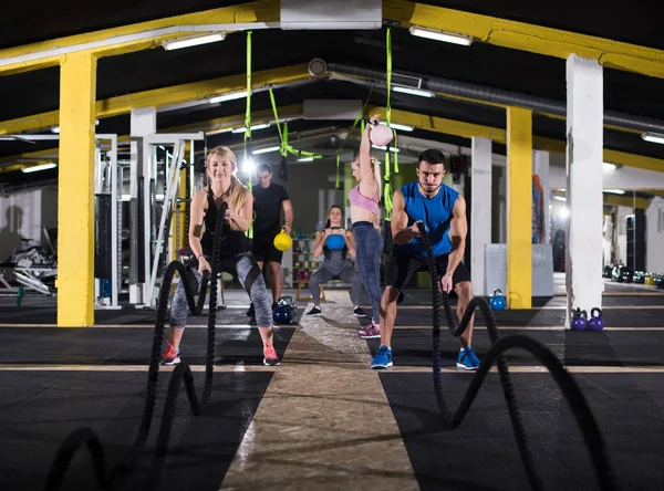 若いフィットスポーツカップルは フィットネスを横断する戦闘ロープを行う機能トレーニングジムで働いて — ストック写真
