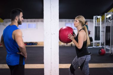 Genç sporcular spor salonunda tıbbi topla antrenman yapıyorlar.