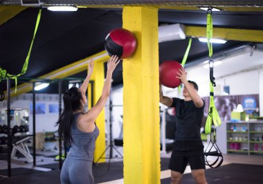 Genç sporcular spor salonunda tıbbi topla antrenman yapıyorlar.