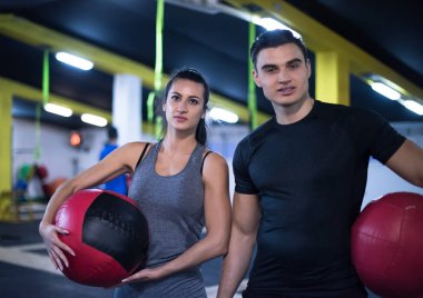 Genç sporcular spor salonunda tıbbi topla antrenman yapıyorlar.