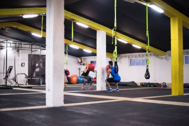 Genç sporcular spor salonunda tıbbi topla antrenman yapıyorlar.
