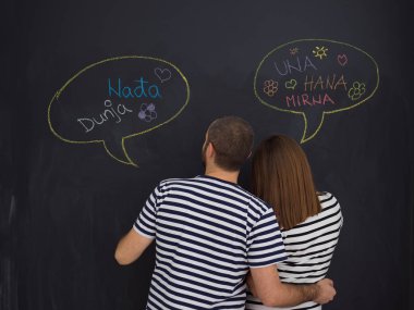 genç hamile çift onların doğmamış bebek için isim düşünmeye ve siyah bir kara tahta yazma