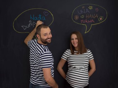 genç hamile çift onların doğmamış bebek için isim düşünmeye ve siyah bir kara tahta yazma