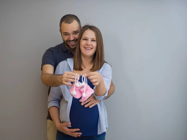 Νεαρή Έγκυος Ζευγάρι Κρατώντας Νεογέννητο Μωρό Παπούτσια Που Απομονώνονται Λευκό — Φωτογραφία Αρχείου