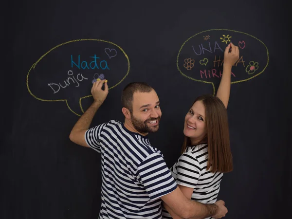 genç hamile çift onların doğmamış bebek için isim düşünmeye ve siyah bir kara tahta yazma