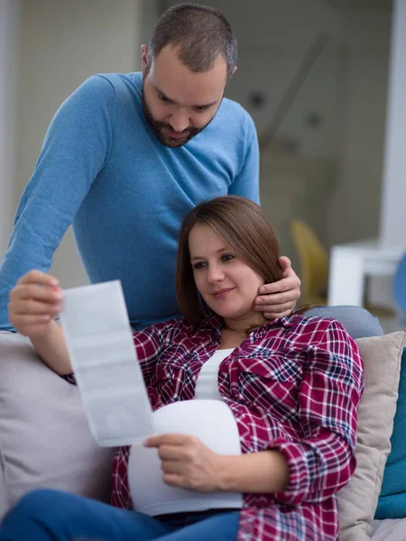 Junges Schwangeres Paar Sucht Baby Ultraschall Foto Während Sich Hause — Stockfoto