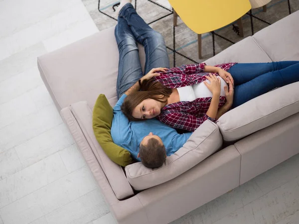 evde kanepe kanepede rahatlatıcı mutlu hamile çiftin üstten görünüm