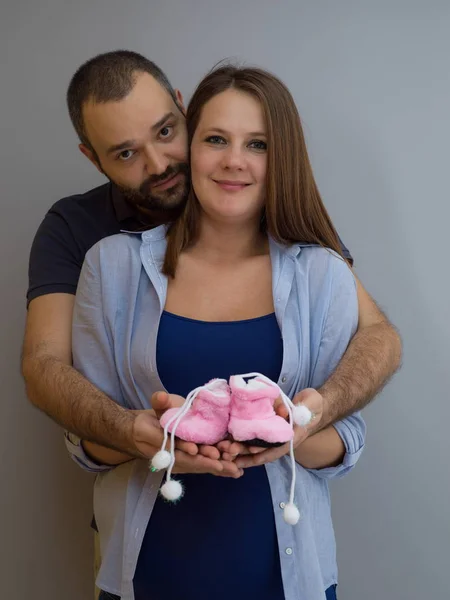 Young Pregnant Couple Holding Newborn Baby Shoes Isolated White Background — Stock Photo, Image