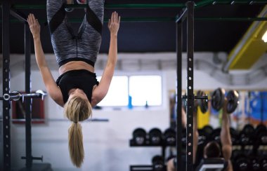 sporcu kadın fitness spor çapraz yatay çubuk üzerinde baş aşağı asılı abs egzersizleri yapıyor