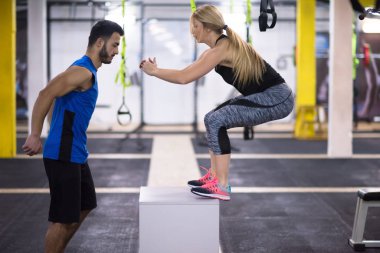 Kişisel antrenörle antrenman yapan genç atletik kadın spor salonunda forma giydi.