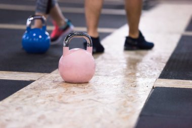 Çapraz fitness stüdyosunda kettlebell egzersizleri yapan bir grup sağlıklı genç sporcu.