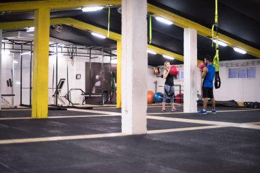 Genç sporcular spor salonunda tıbbi topla antrenman yapıyorlar.