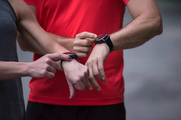 年轻的运动型情侣在慢跑前使用智能手表启动计时器 — 图库照片