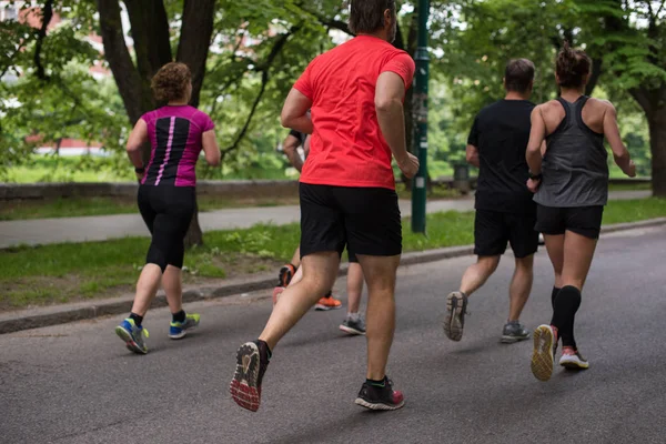 group of healthy people jogging in city park, runners team on morning training