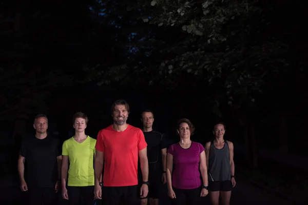 一组健康的人在城市公园慢跑 赛跑选手在夜间训练 — 图库照片