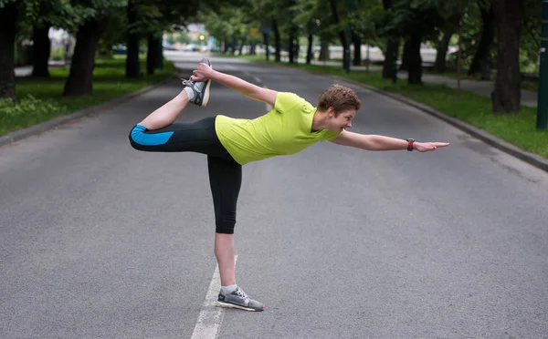 ウォーミング アップやストレッチ朝トレーニングの前に都市公園における健康の女性ランナー — ストック写真