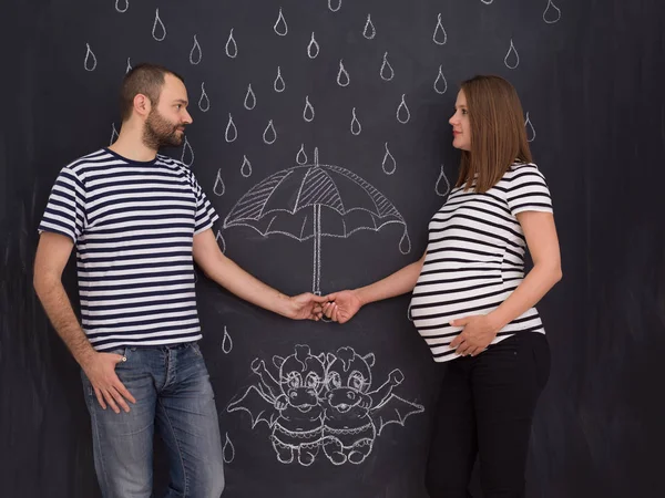 怀孕夫妇的概念照片绘制他们的想象力未来的生活与儿童粉笔板 — 图库照片