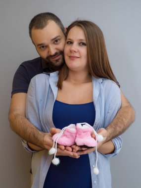 genç hamile çift yeni doğmuş bebek patiği aile ve ebeveynlik kavram beyaz arka plan üzerinde izole holding