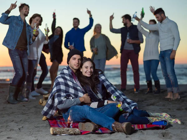 Pareja Joven Sentada Con Amigos Alrededor Campfire Beach Atardecer Bebiendo —  Fotos de Stock