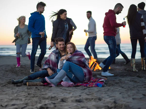 Genç Çift Gün Batımında Arkadaşlarıyla Kumsalda Oturmuş Bira Içiyorlardı — Stok fotoğraf