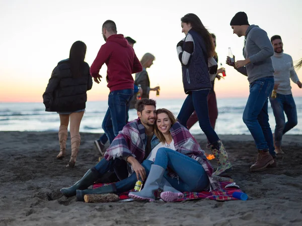 Genç Çift Gün Batımında Arkadaşlarıyla Kumsalda Oturmuş Bira Içiyorlardı — Stok fotoğraf