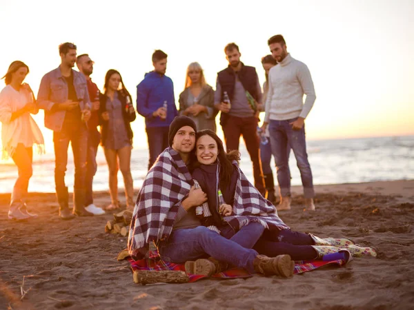Genç Çift Gün Batımında Arkadaşlarıyla Kumsalda Oturmuş Bira Içiyorlardı — Stok fotoğraf