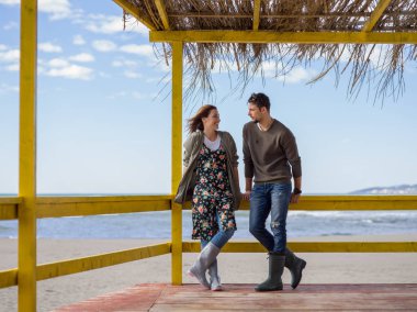 Mutlu çift, sonbahar günü kumsalda birlikte vakit geçiriyorlar.